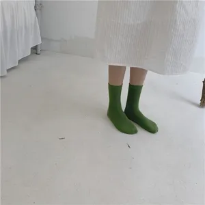 Détail de chaussettes mi-hautes côtelées vertes, en coton doux, style décontracté.