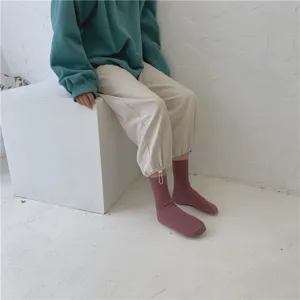 Vue détaillée de chaussettes unies côtelées mi-mollet portées en tenue décontractée.
