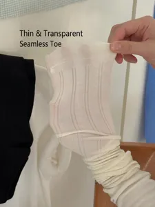 Close-up of thin sheer white socks showing the smooth seamless toe and delicate ribbed texture.