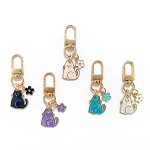 Detailed view of colorful pearlescent cat keychains with cute flower charms and gold clasps.