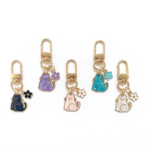 Detailed shot of cute cat keychains with pearl enamel finish and matching floral charms.