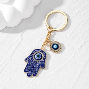 Gros plan détaillé du porte-clés main de Fatima mauvais œil, avec des strass étincelants dorés.