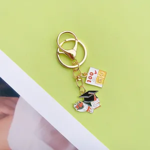 Metal graduation theme keychain detail charm featuring cute book and score pendant.