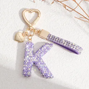 Porte-clés lettre K en strass violet luxueux avec charm cœur et lanière scintillante pour sac.