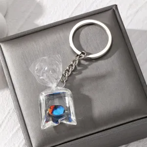 Close-up detail of the creative resin tropical fish water bag pendant keychain on pad.