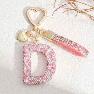 Vue détaillée d'un porte-clés lettre D en strass rose scintillant avec fermoir en cœur.