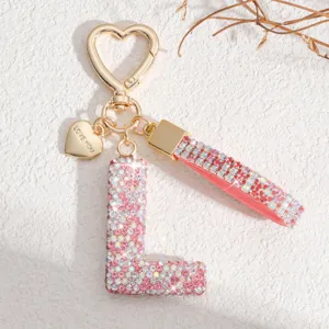 Porte-clés lettre L en strass avec fermoir cœur et lanière rose pour sacs et clés de voiture.