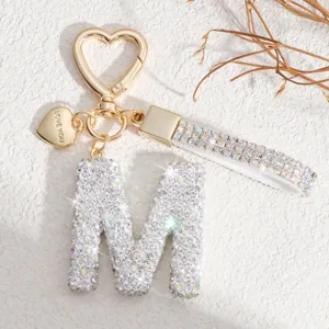 Vue rapprochée détaillée du porte-clés lettre M en strass brillant et fermoir cœur.