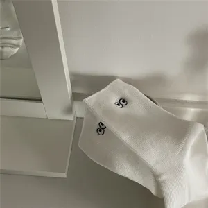 Gros plan détaillé sur des chaussettes blanches en coton avec de jolis yeux brodés.
