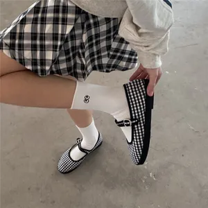 Chaussures Mary Jane à carreaux noirs et blancs associées à de jolies chaussettes blanches.