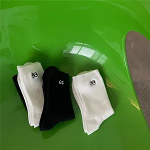 Chaussettes mi-hautes en coton avec jolie broderie de petits yeux en noir et blanc.