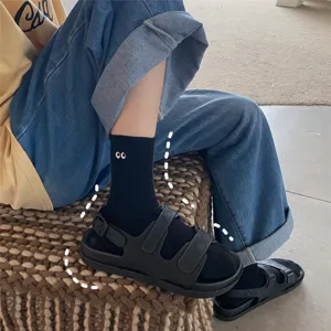 Chaussettes mi-hautes en coton noir pour femmes avec motif de petits yeux mignons et tendance.