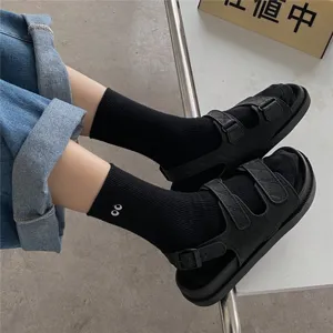 Chaussettes mi-hautes noires en coton avec jolie broderie d'yeux et sandales assorties.