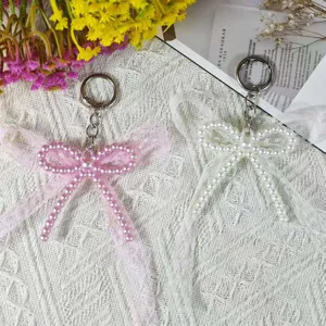 Handmade DIY faux pearl double layer bow keychain with sweet lace charm for bag decor.
