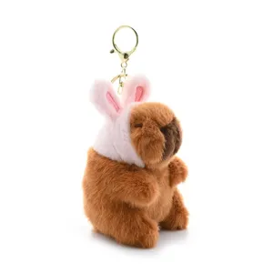 Cute capybara plush keychain detail featuring soft brown fur and lovely pink bunny ears, gold hardware.