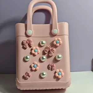 Vista dettaglio della borsa mare rosa in EVA con perle, fiocchi e decorazioni floreali.