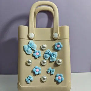 Dettaglio borsa da spiaggia EVA beige, ciondoli fiocco perle fiori, borsa estiva.