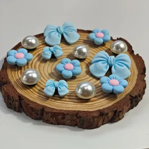 Primo piano di simpatiche decorazioni di borse e scarpe con fiori e perle blu.