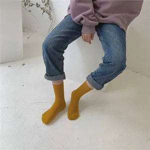 Vue détaillée de chaussettes mi-hautes côtelées jaunes portées par un mannequin studio.
