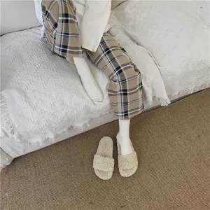 Vue détaillée de chaussettes unies style slouch portées avec des pantoufles confortables.