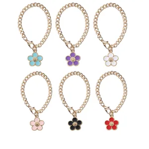 Detailed view of colorful enamel flower cup chain with smiley face charm and metal link.