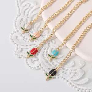 Close-up view of cute enamel tulip charms on gold chains, perfect for tumbler cup decoration.