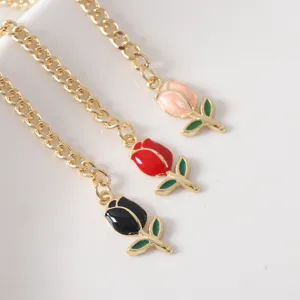 Detail shot of sweet tulip cup chains featuring pink, red and black enamel flower pendants.