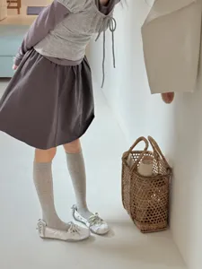 Detailed view of casual grey calf socks paired with white shoes and skirt, comfortable wear.