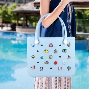 Detalle de bolso de playa EVA azul claro con lindos dijes de verano para las vacaciones.