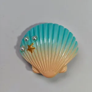 Detailed view of seashell hole bag charm, blue gradient with pearls and starfish.