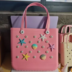 Pink rubber beach tote bag detail featuring pearl and starfish charm accessories for summer.