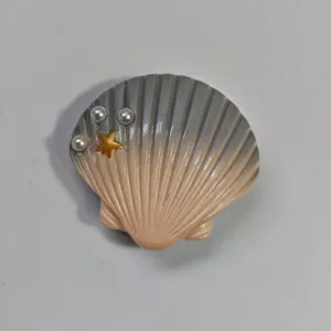 Seashell star bag charm detail, ocean theme hole bag decorative snap buckle accessory.