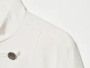 Weisse Blazer Detailansicht mit strukturierter Schulter, Stehkragen und Metallknopf.