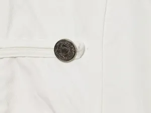 Detailansicht der eleganten weißen Damenblazer Textur mit luxuriösem Metallknopf und Riemen.