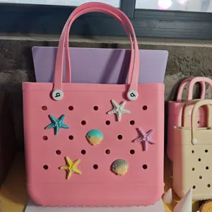 Pink EVA beach bag with starfish and seashell charms, waterproof perforated tote bag for summer.