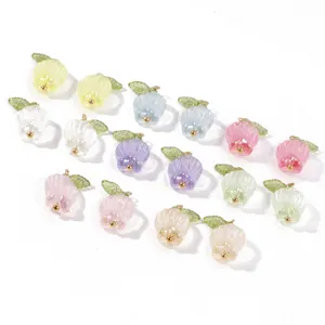 Close up of colorful tulip charms with green leaves and gold loops for handmade DIY crafts.