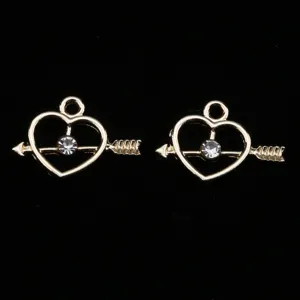Gold tone heart arrow alloy charm detail shot, sparkling rhinestone diy jewelry accessory.