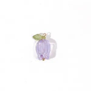 Close-up detail view of a purple floral pendant charm with green leaf and gold loop decor.