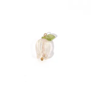 Handmade tulip pendant detail, translucent pearlescent flower with green leaf and gold loop.