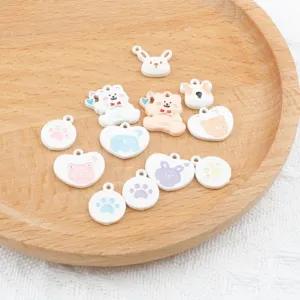 Close-up detail of cute alloy DIY charms featuring lovely bear, paw and heart shapes for jewelry.