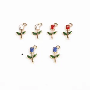 Dettaglio in primo piano di ciondoli a forma di rosa smaltata con foglie verdi e anello.