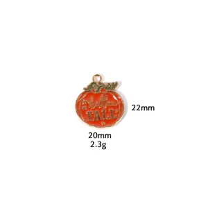 Detail shot of the enamel pumpkin pendant showcasing metal texture and vibrant autumn colors.