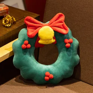 Close-up detail of the cute Christmas wreath plush toy pillow with red bow and bell.