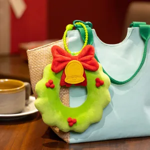Plush Christmas wreath bag charm detail, cute holiday decoration pendant with red bow and bell.