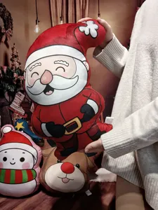 Detailansicht des niedlichen Plüsch-Weihnachtsmanns als Kissen, weicher Kuschelkissen-Stoff.