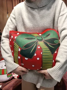 Rotes Weihnachts Geschenkbox Kissen aus Plüsch mit grüner Schleife für Sofadeko Detailansicht.