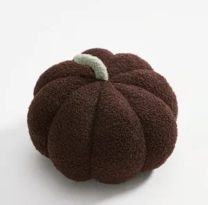 Close-up detail of the cozy brown plush pumpkin pillow, soft fuzzy texture and cute green stem.