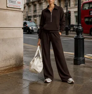Street style detail view of the brown half-zip sweatshirt and loose tracksuit pants set.