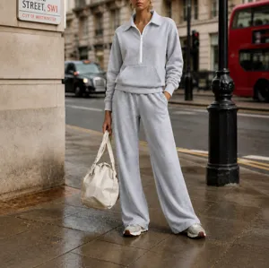 Detail shot of a casual light grey half-zip sweatshirt and wide-leg sweatpants set.