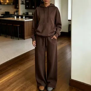 Dettaglio del set felpa con cappuccio e pantaloni marrone con consistenza e vestibilità.